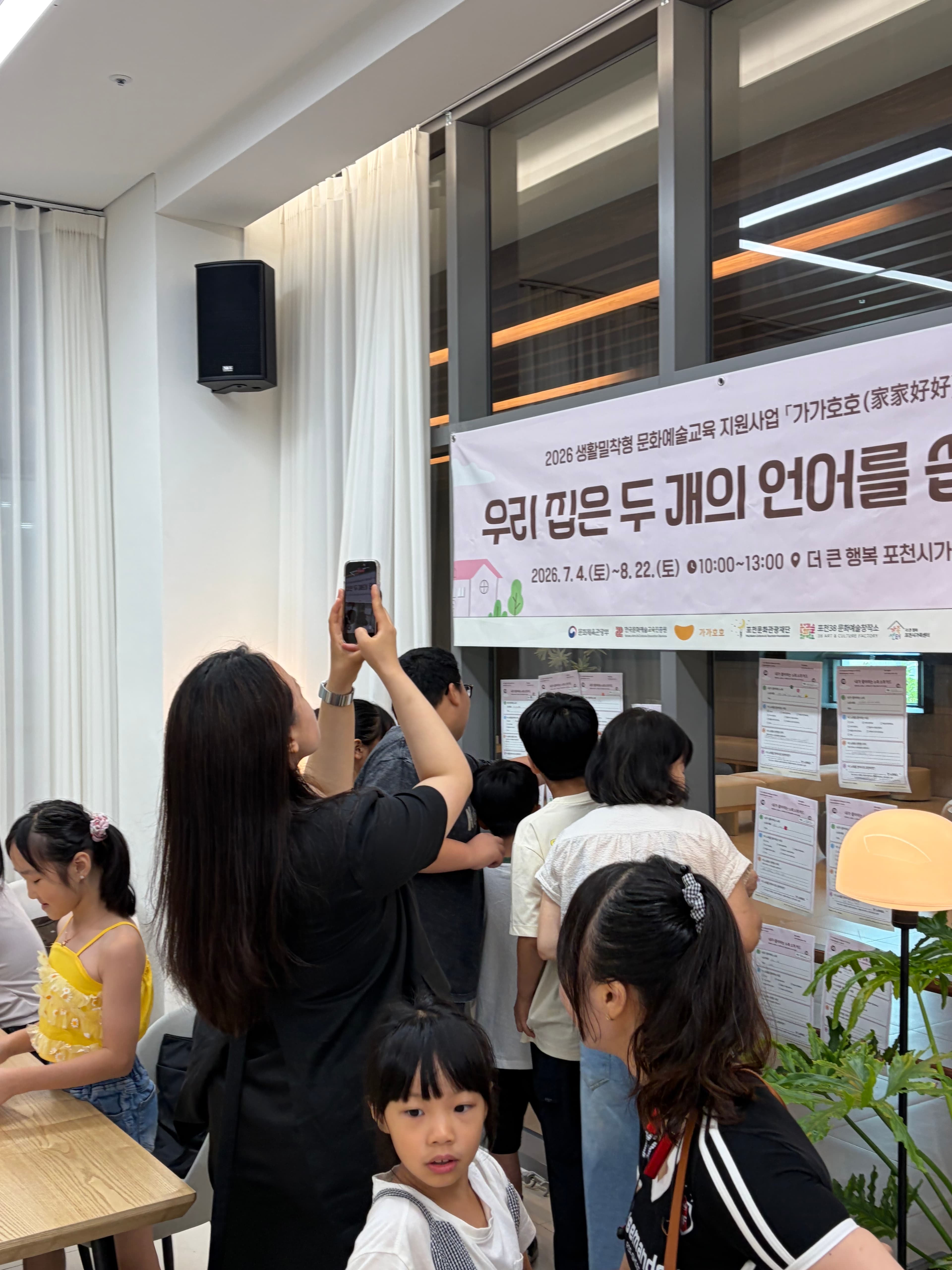 프로그램 등록 현장, 안내 배너 앞에 모인 참여 가족들