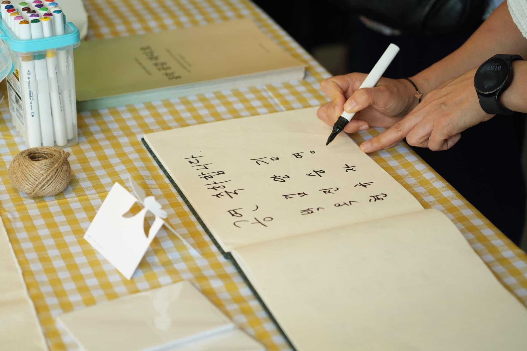 행사 프로그램북에 손글씨로 메시지를 적는 손