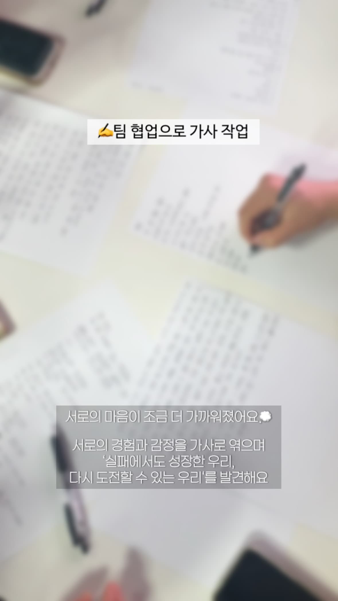 손으로 쓴 가사 초안 워크시트에 팀원이 문장을 적는 모습