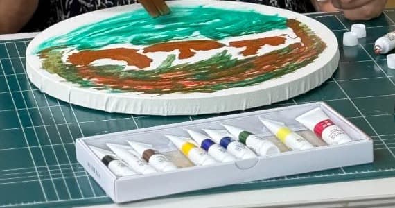원형 캔버스에 초록빛 하늘과 갈색 바위, 짙은 초록 들판을 그린 작품 「푸른바다의 여름」
